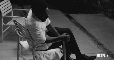 a man sitting in a chair with his feet crossed