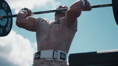 a man holding a barbell above his head