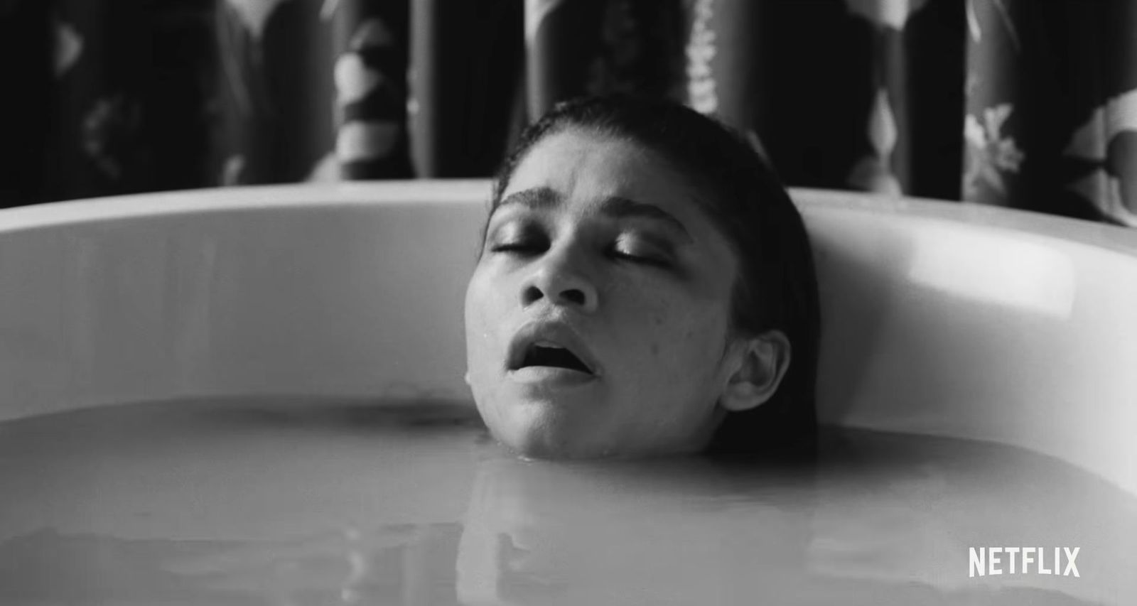 a woman laying in a bathtub with her eyes closed