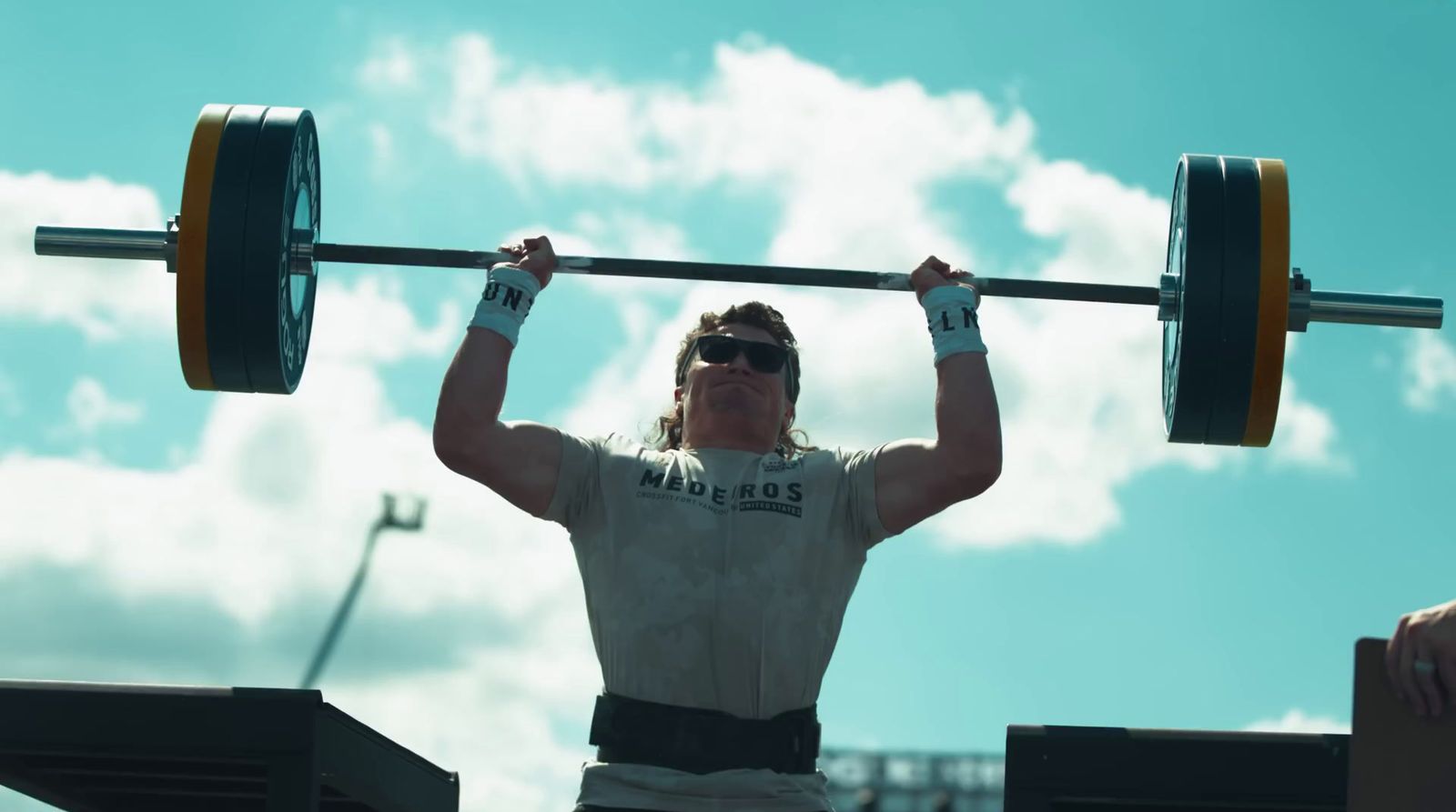 a man holding a barbell above his head