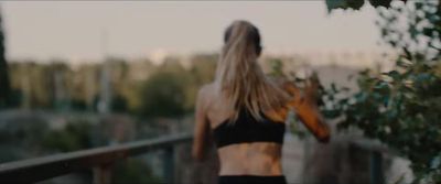 a woman in a black top is standing on a bridge