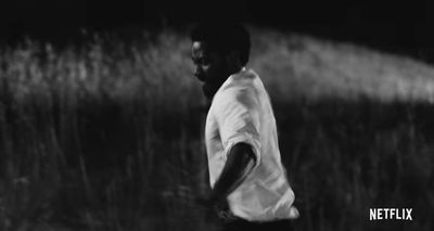 a man standing in a field of tall grass