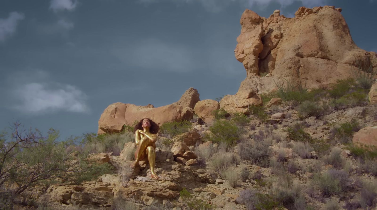 a woman standing on top of a rocky hillside