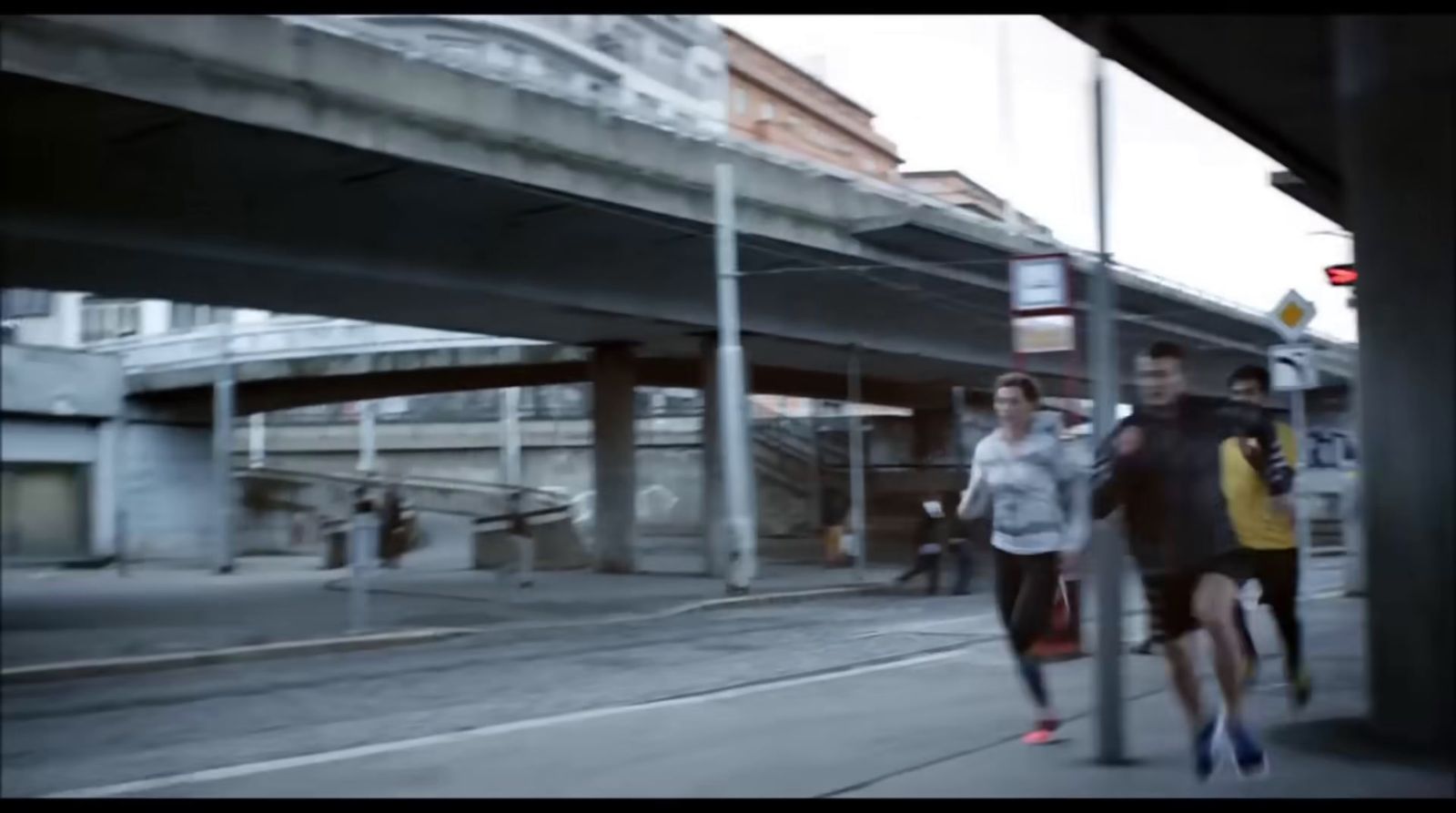 a group of people walking down a street next to a traffic light