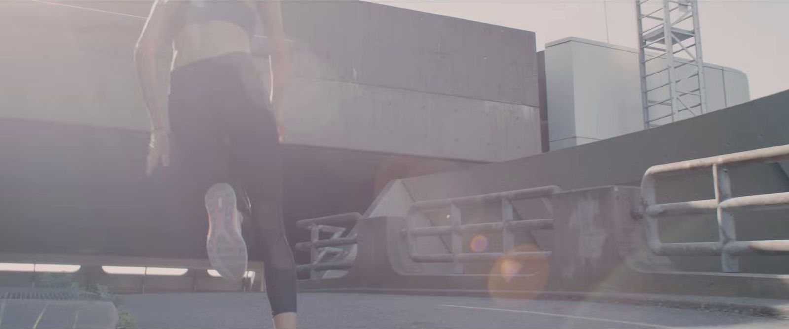 a woman in a black dress walking down a street