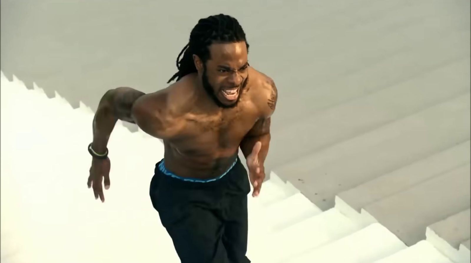 a man with dreadlocks running down a set of stairs