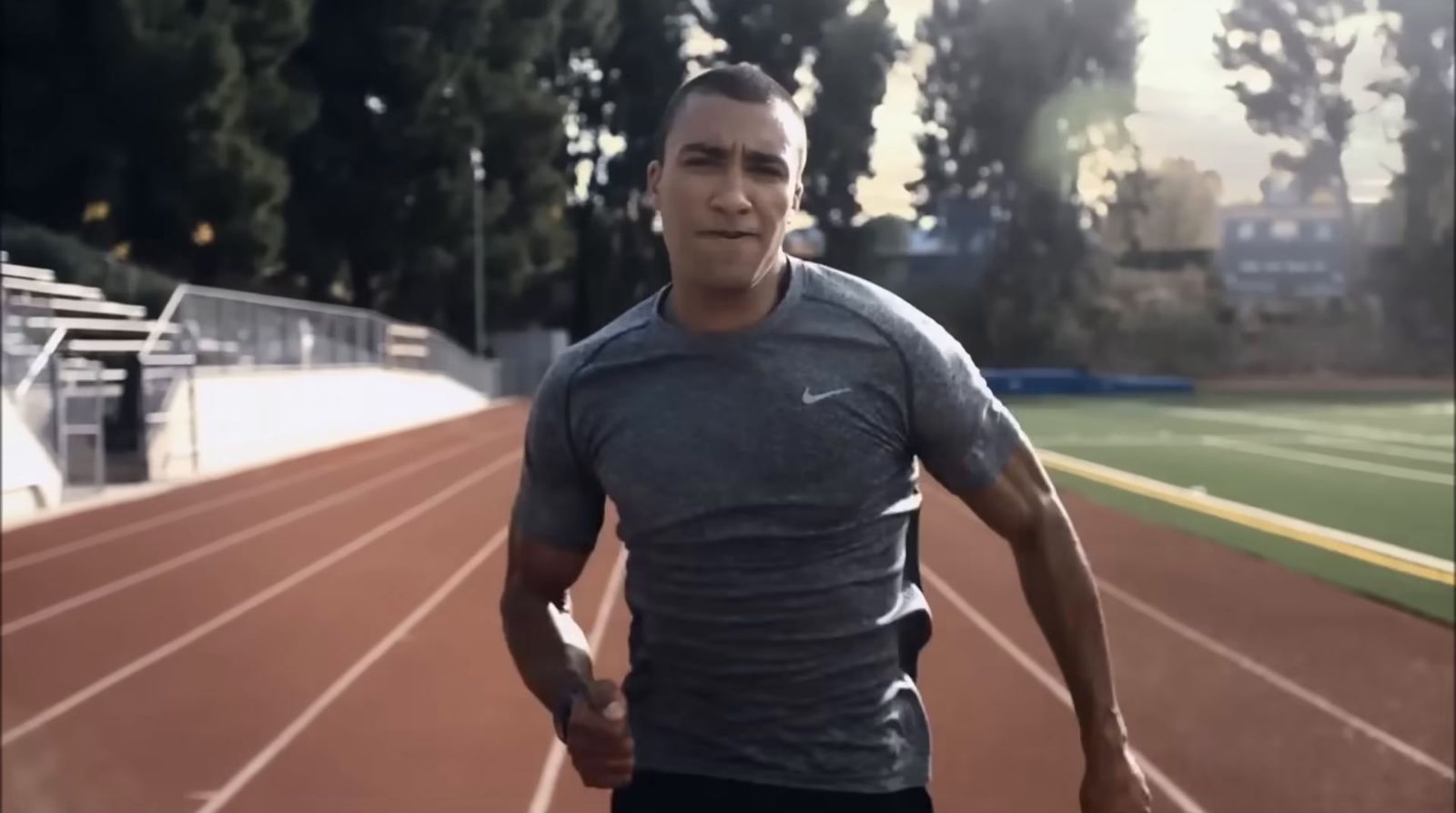 a man is running on a track with trees in the background