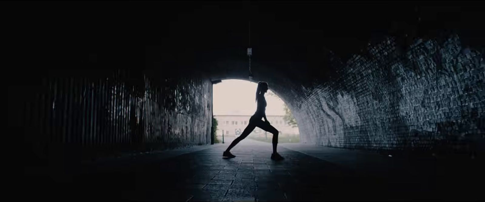 a person doing a handstand in a dark tunnel