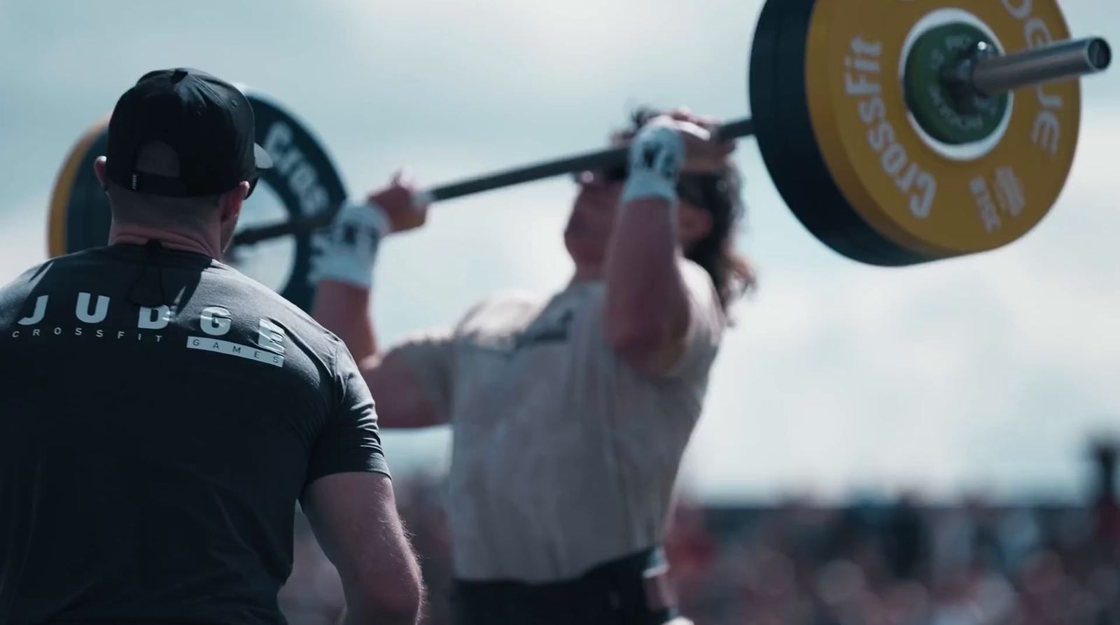 a man holding a barbell in front of another man