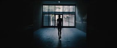 a person standing in front of a window in a dark room