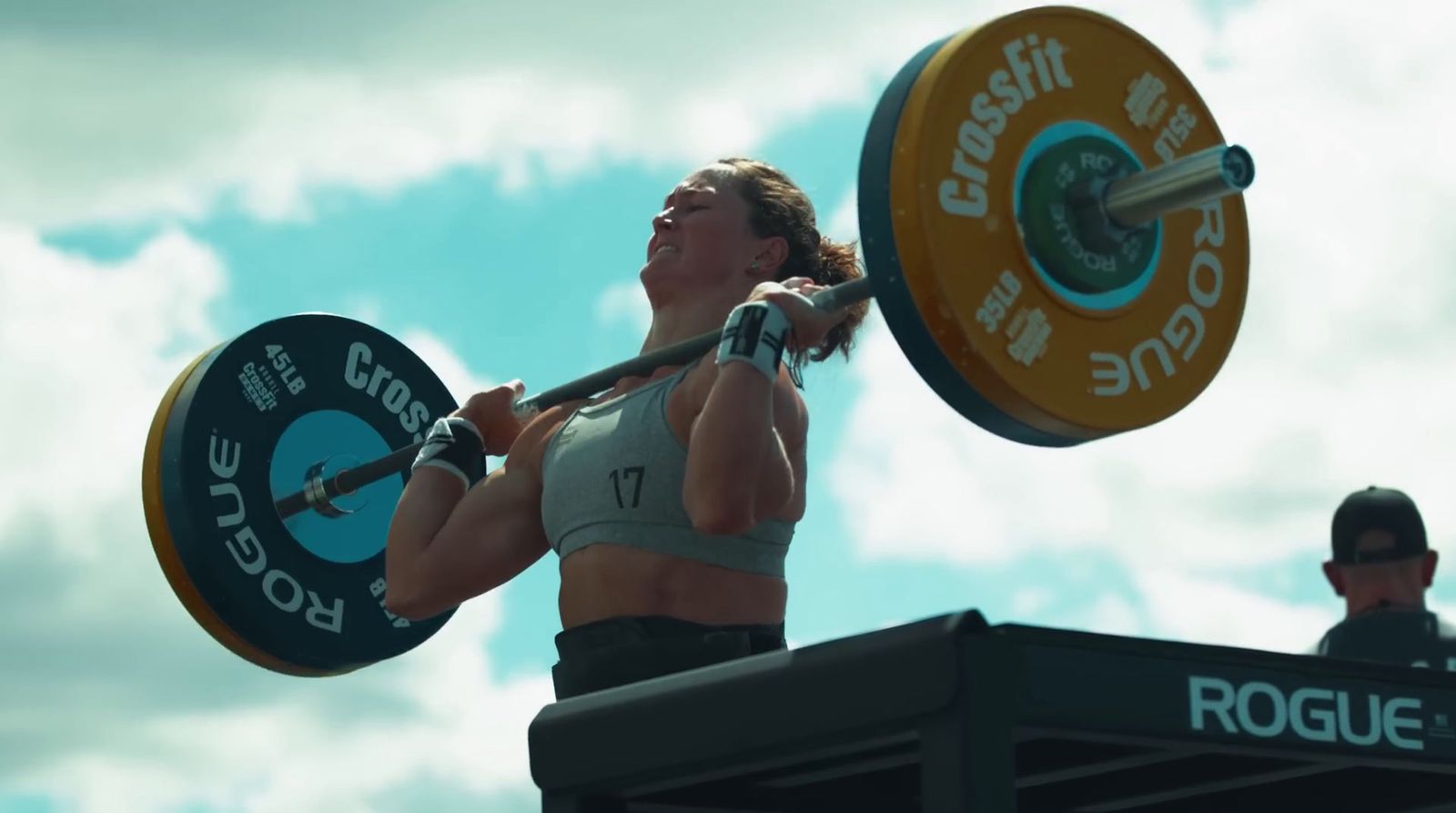 a woman lifting a barbell on top of a roof