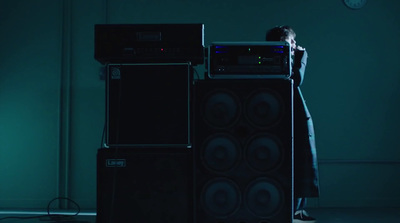 a man standing next to a stack of speakers