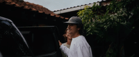 a man standing next to a car talking on a cell phone