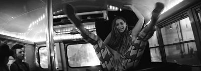 a black and white photo of a woman on a subway