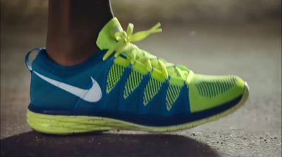 a close up of a person's shoe with a green and blue shoelace