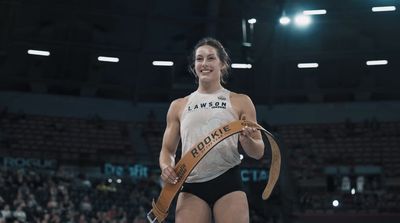 a woman in a white shirt and black shorts holding a brown belt