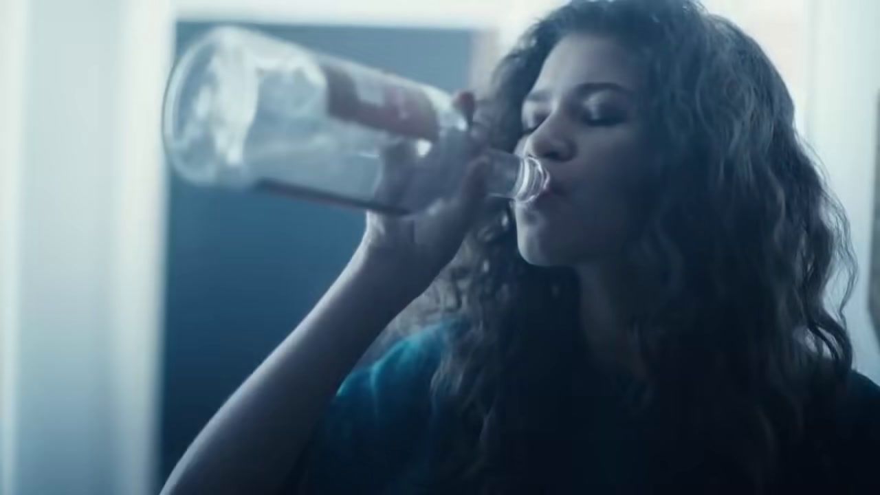 a woman drinking water from a bottle