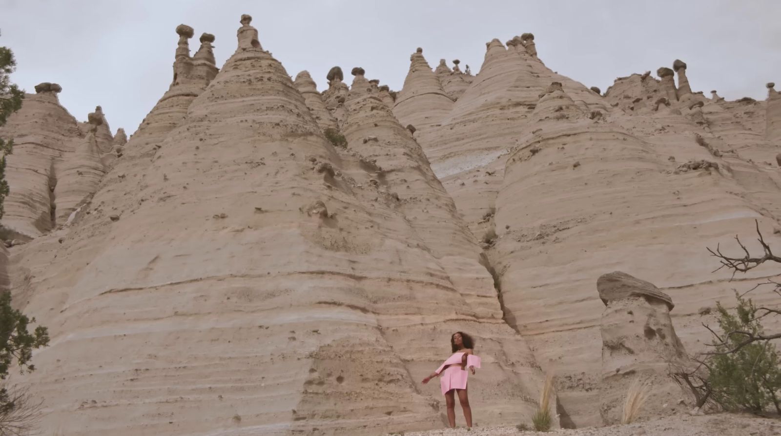 a little girl standing in front of a sand castle