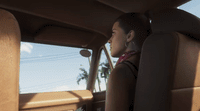 a woman sitting in the back seat of a car