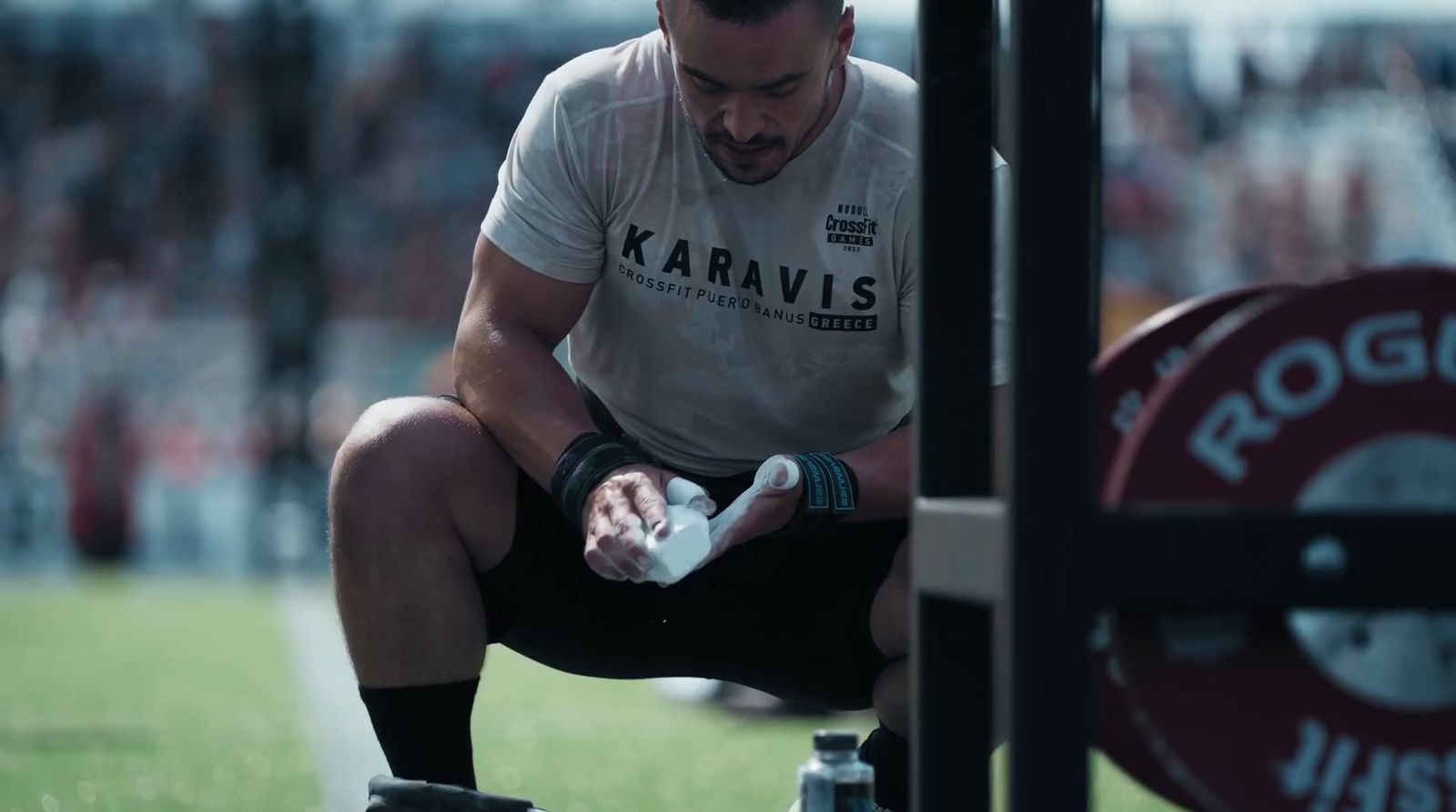 a man squatting down with a bandage on his hand