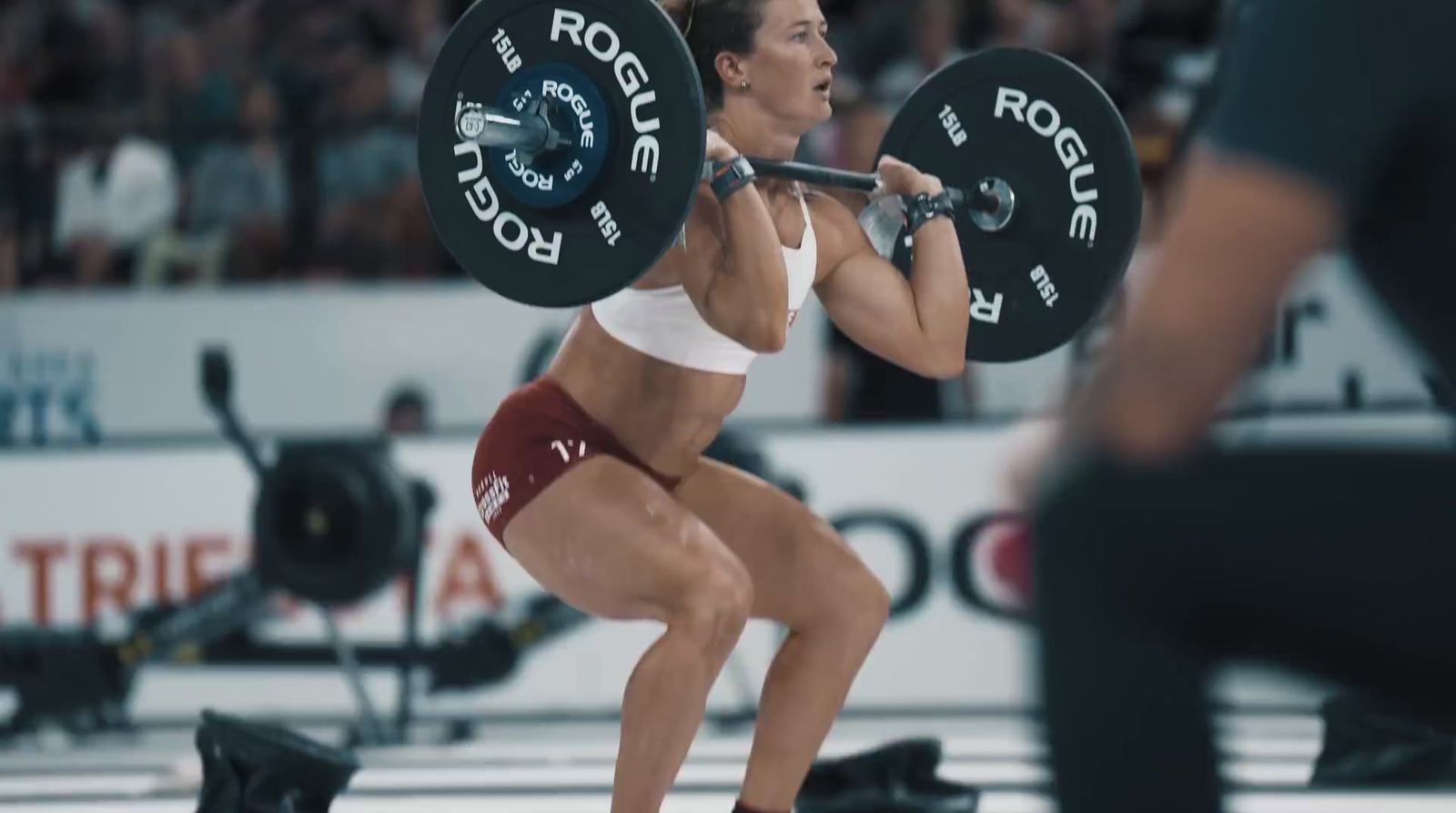 a woman lifting a barbell during a crossfit competition