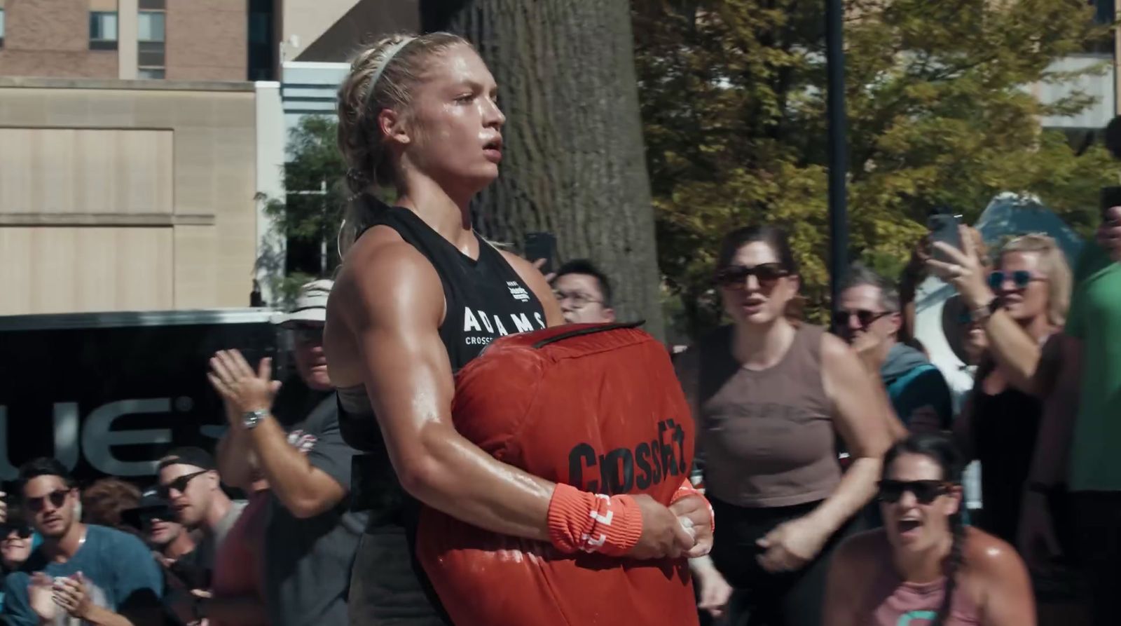 a woman holding a red frisbee in front of a crowd of people