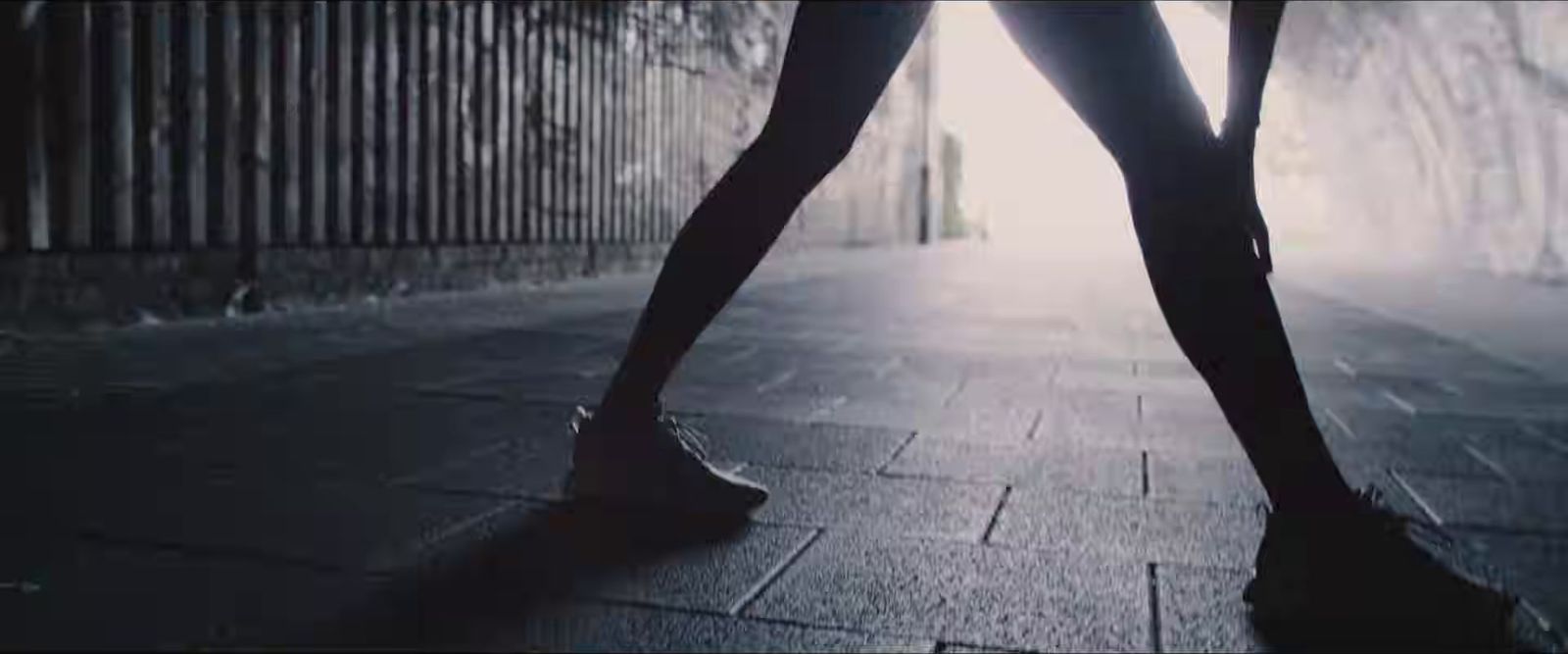 a woman walking down a sidewalk in high heels