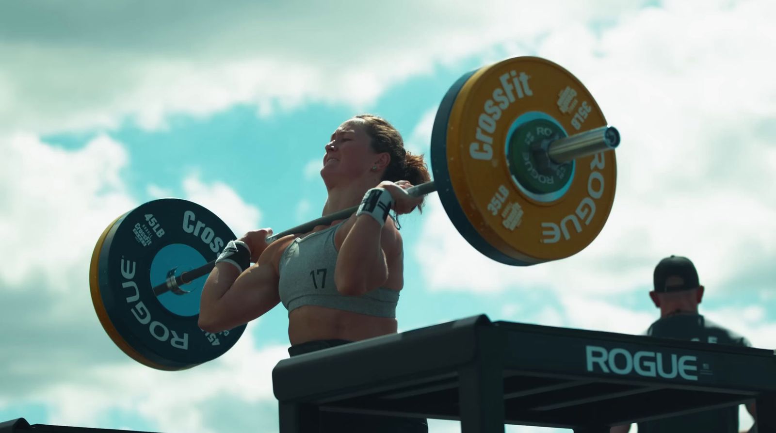 a woman holding a barbell during a competition