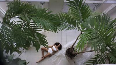 a woman in a white dress laying on a tiled floor