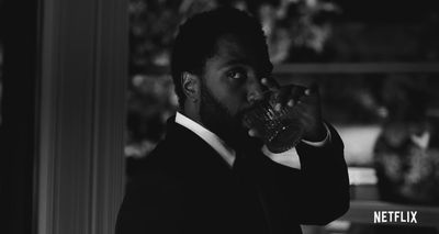 a man in a suit drinking from a glass