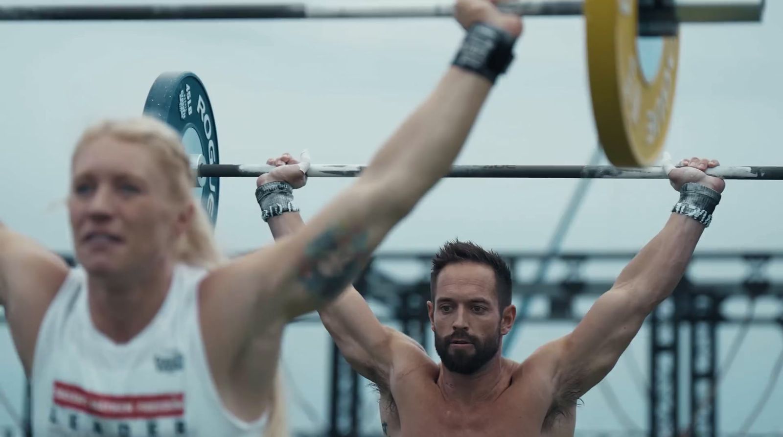 a man and a woman holding a barbell