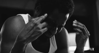 a black and white photo of a man holding his hands to his face