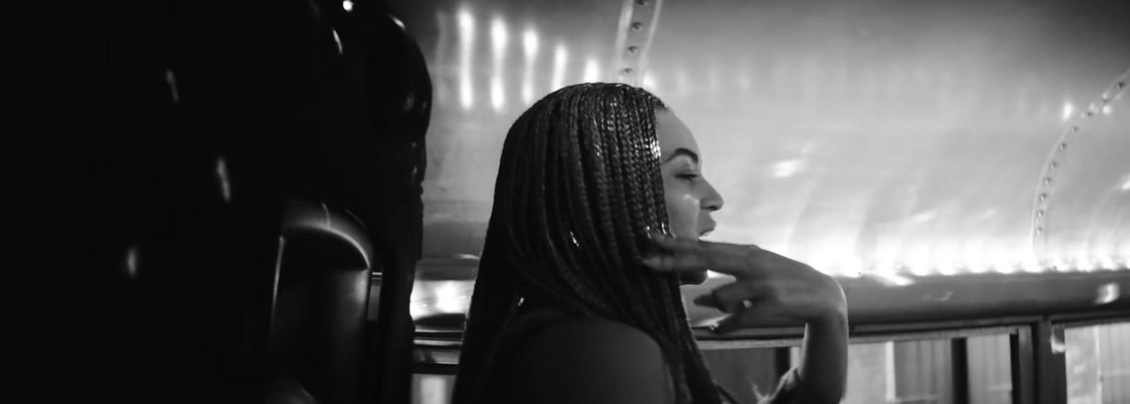 a black and white photo of a woman with braids