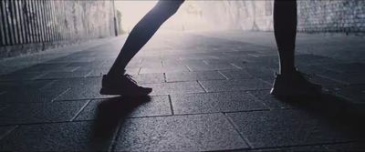 a person standing on a tiled floor with their feet in the air