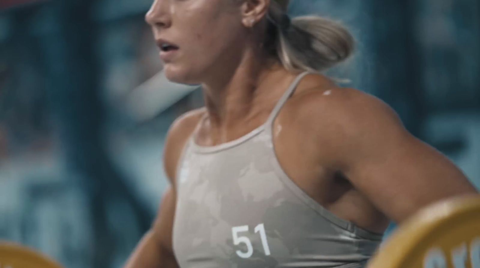 a woman holding a barbell in a gym