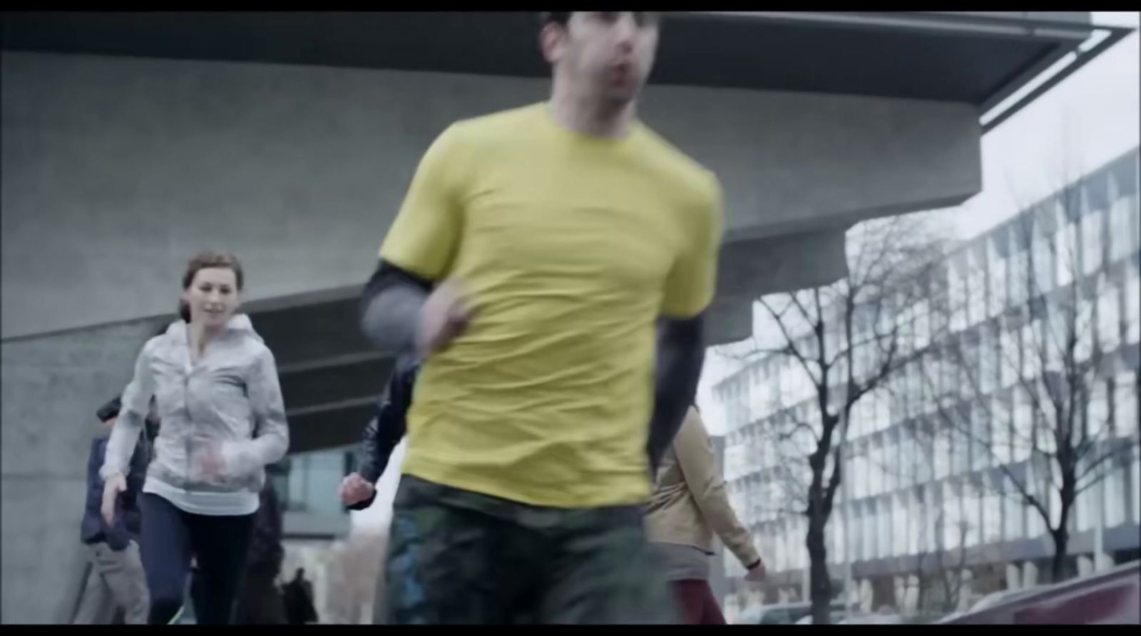 a group of people walking down a street next to tall buildings