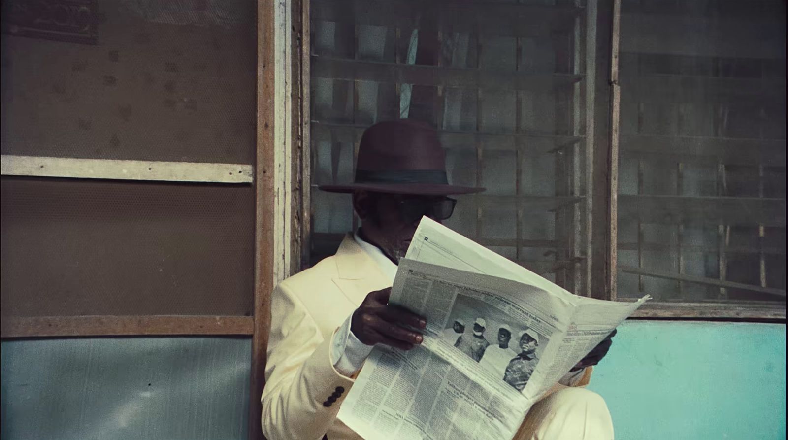 a man in a hat reading a newspaper