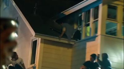 a group of people standing outside of a house at night