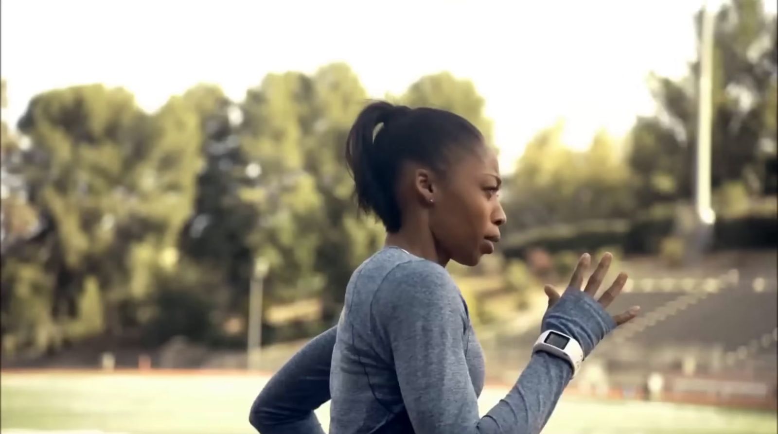 a woman in a gray shirt is holding her hands together