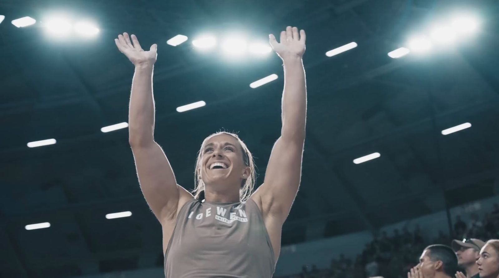 a female basketball player raising her arms in the air