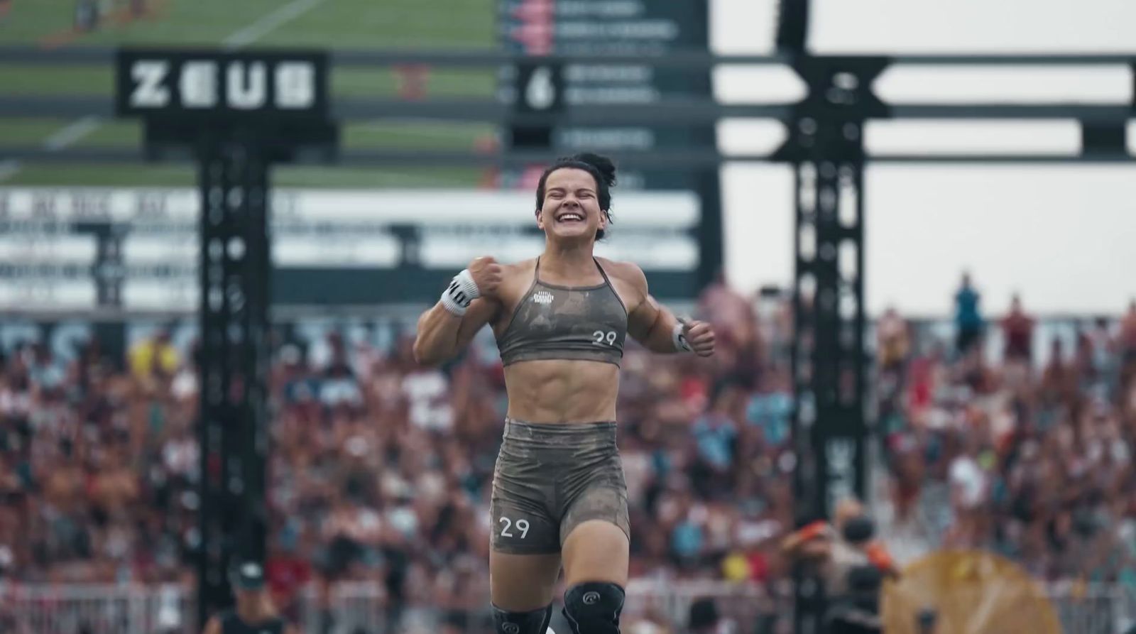 a woman is running in front of a crowd