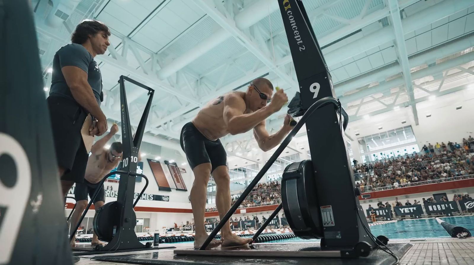 a man standing next to a machine in a swimming pool