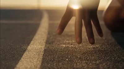 a person's hand reaching for a light on a road