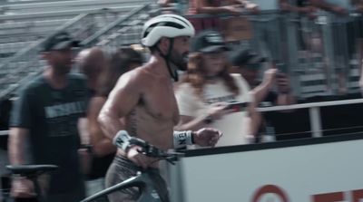 a man riding a bike next to a crowd of people