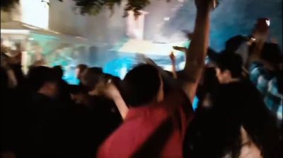 a group of people standing in front of a fish tank