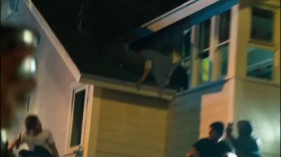 a group of people standing outside of a house at night