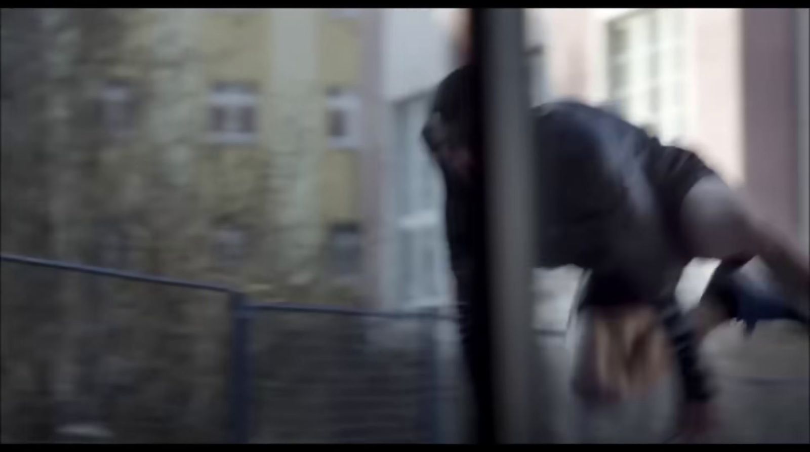 a blurry photo of a man leaning against a wall