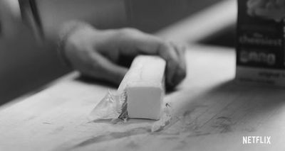 a person holding a block of wax on a table