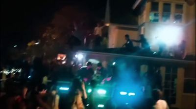 a group of people riding on the back of a truck at night