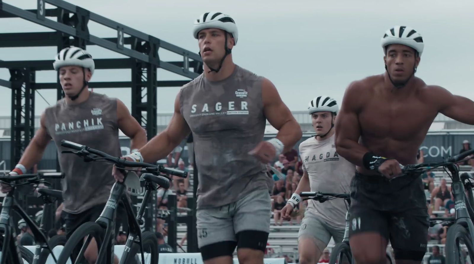 a group of men riding bikes down a street